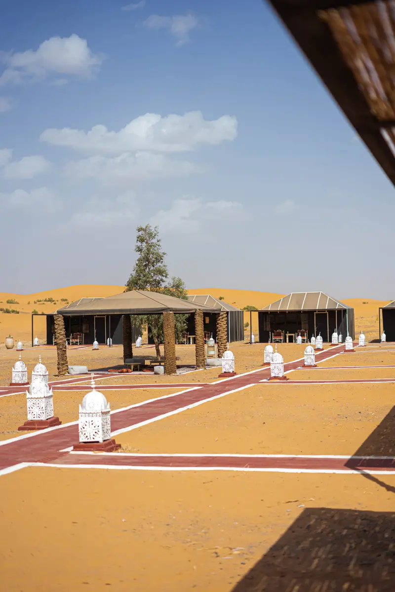Tassili camp by day, with the sand paths and lanterns between the tents