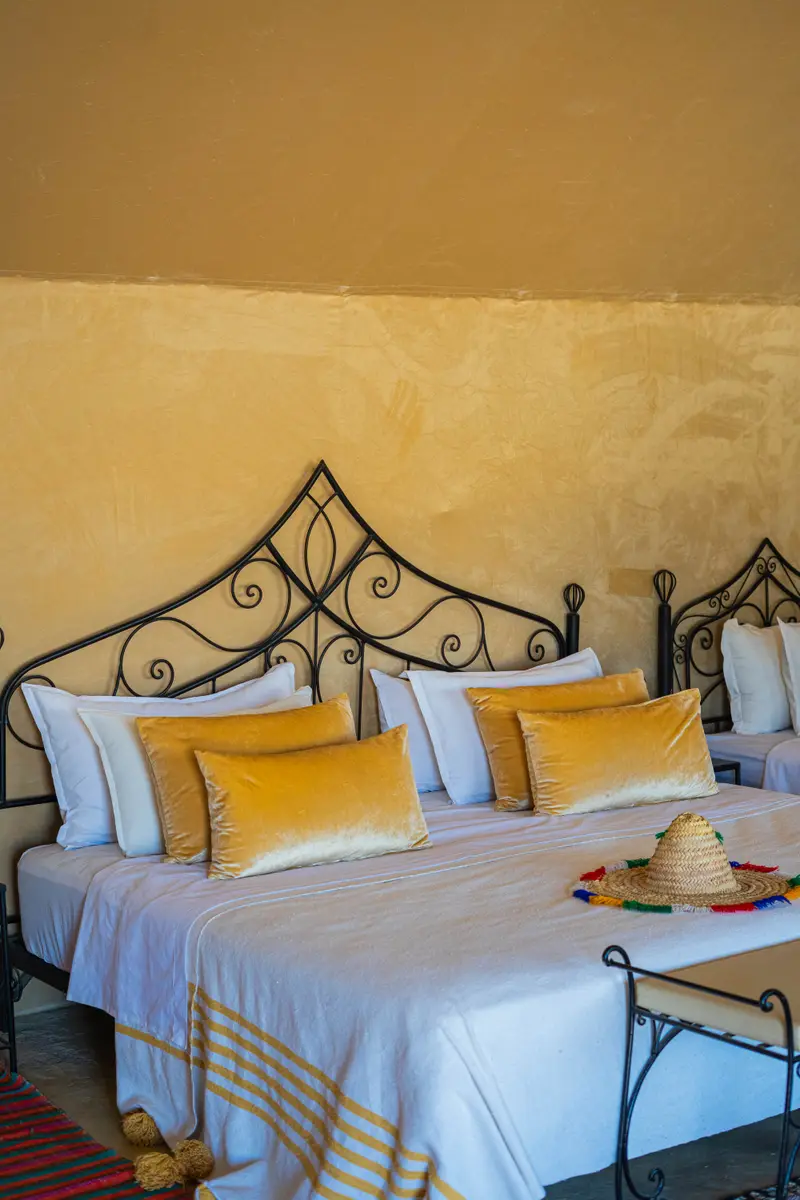 Close-up of the bed and cushions in a luxury tent at Tassili camp