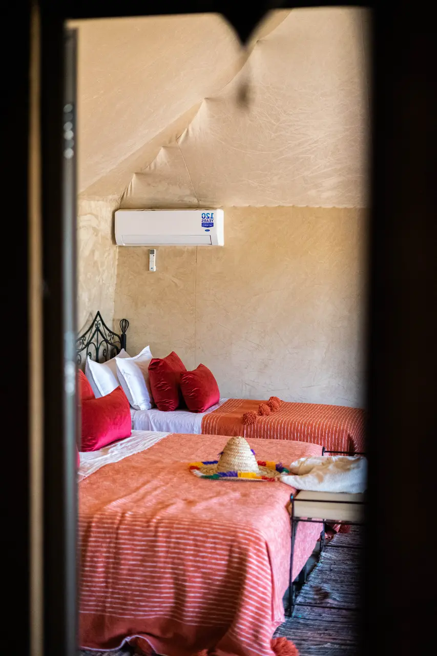 Interior de una jaima con el equipo de aire acondicionado y calefacción sobre la cama