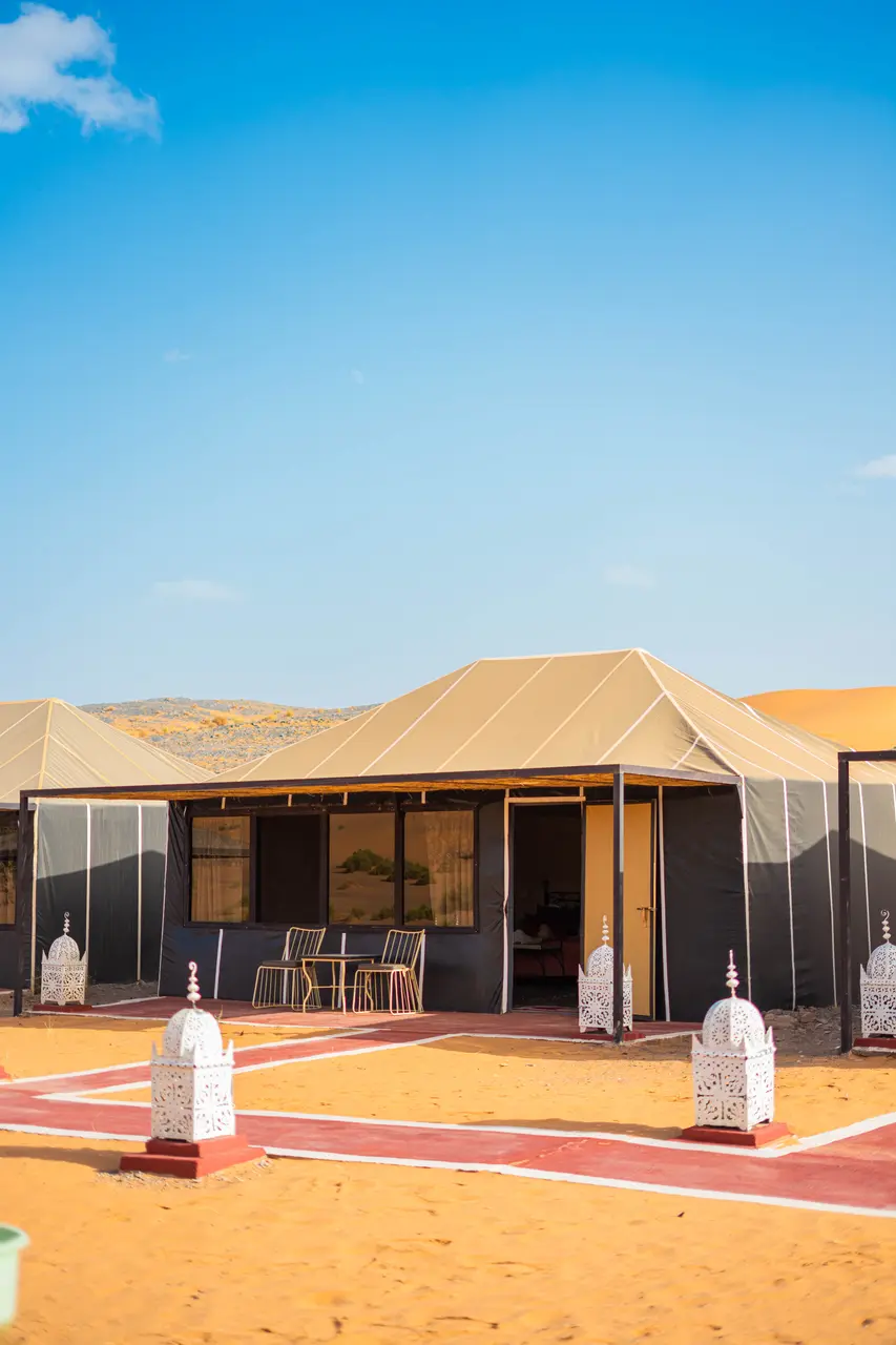 Jaima de lujo con su terraza privada y sillas, de día, en el campamento Tassili