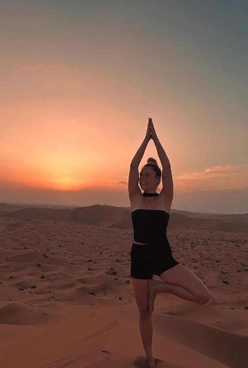 Pratique du yoga au coucher du soleil en haut d’une dune du désert de Merzouga